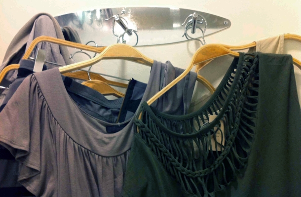 Clothing hangs on dressing room hooks in a confusing way.