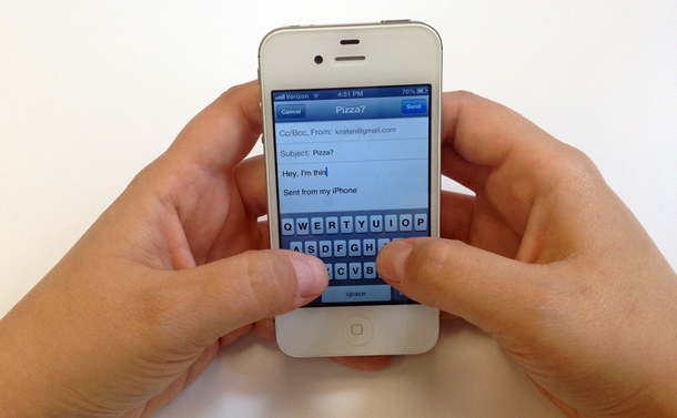 Hands typing message on iPhone, with Sent from my iPhone on the screen