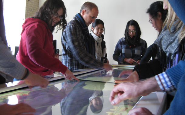 People playing a game around a table surface.